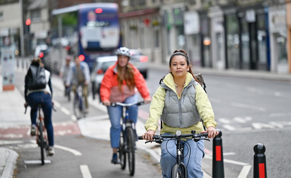 People cycling on a protected, dedicated cycle path in Edinburgh.